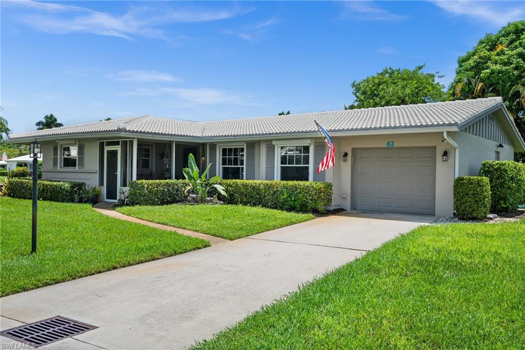62 Lanai Circle, Unit 62 Naples, FL 34112 - Photo 2 of 30 a front view of a house with a yard and potted plants