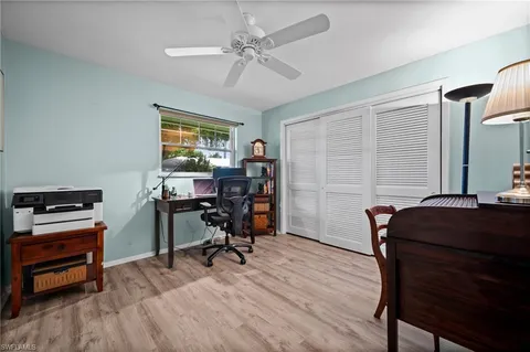 a view of a workspace with furniture and a window