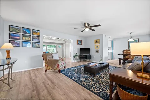 a living room with furniture a flat screen tv and a table
