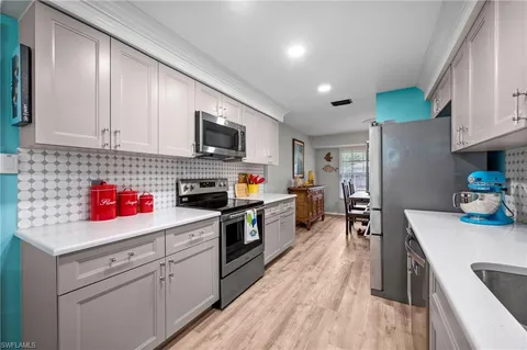 a kitchen with kitchen island granite countertop a sink cabinets and stainless steel appliances