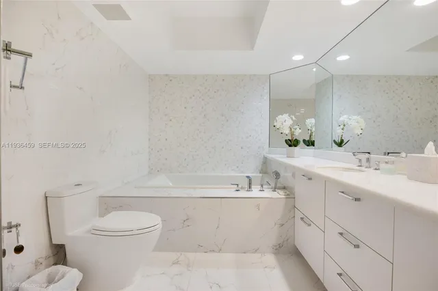 a bathroom with a double vanity sink toilet and bathtub