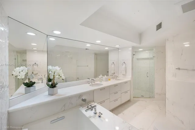 a bathroom with a double vanity sink mirror and shower