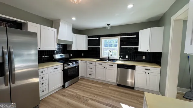 a kitchen with white cabinets and stainless steel appliances