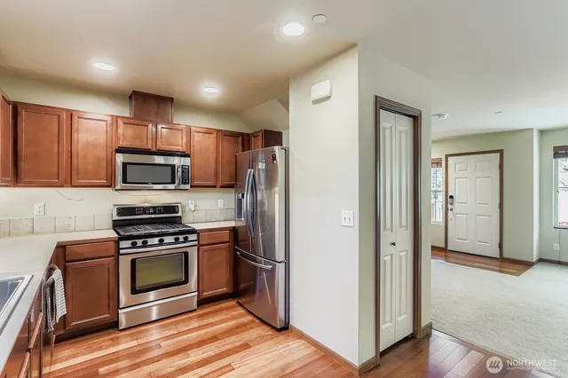 a kitchen with granite countertop a refrigerator and a stove top oven