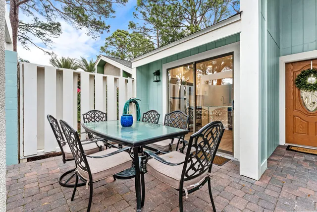 a patio with table and chairs and potted plants