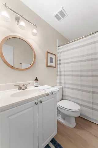 a bathroom with a granite countertop toilet a sink and a mirror