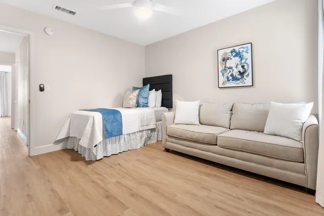 a living room with furniture white walls and wooden floor