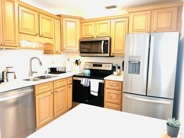 a kitchen with stainless steel appliances a refrigerator stove microwave and sink