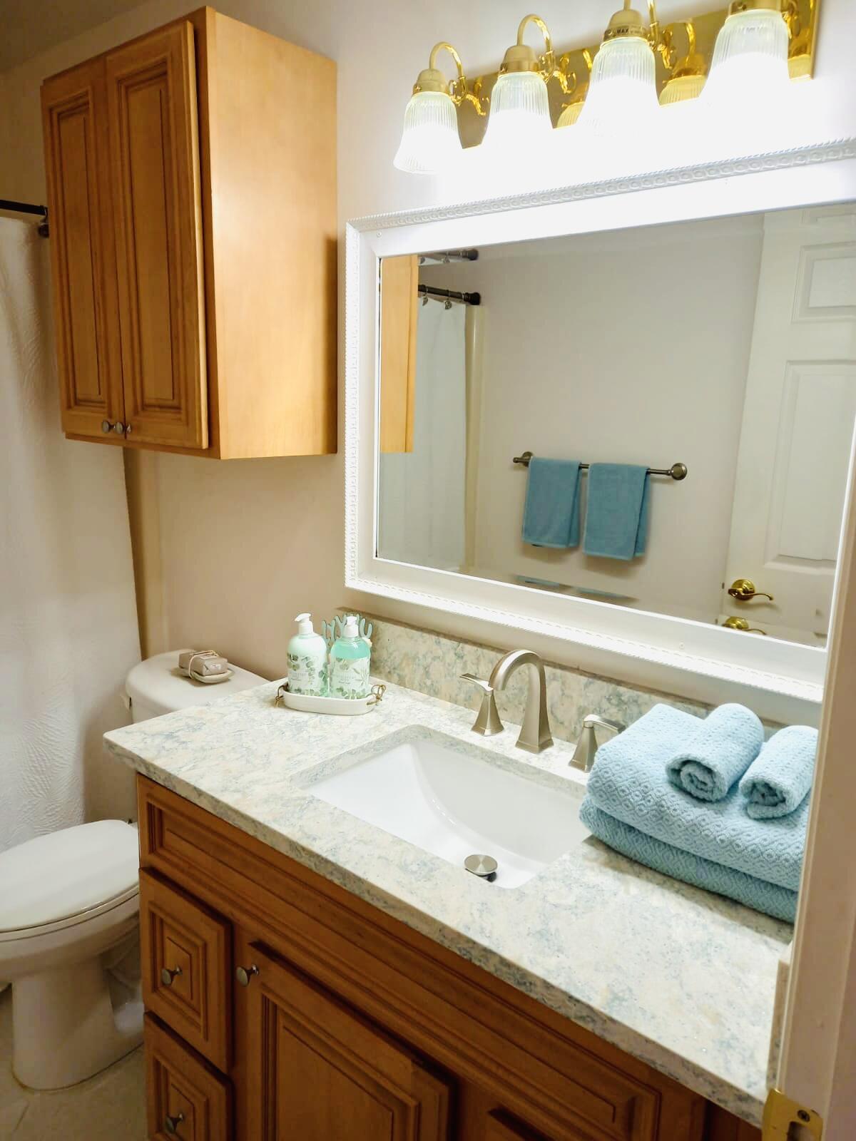80 Crooked Tree Lane, Unit 106 Vero Beach, FL 32962 - Photo 22 of 47 a bathroom with a granite countertop sink and a mirror