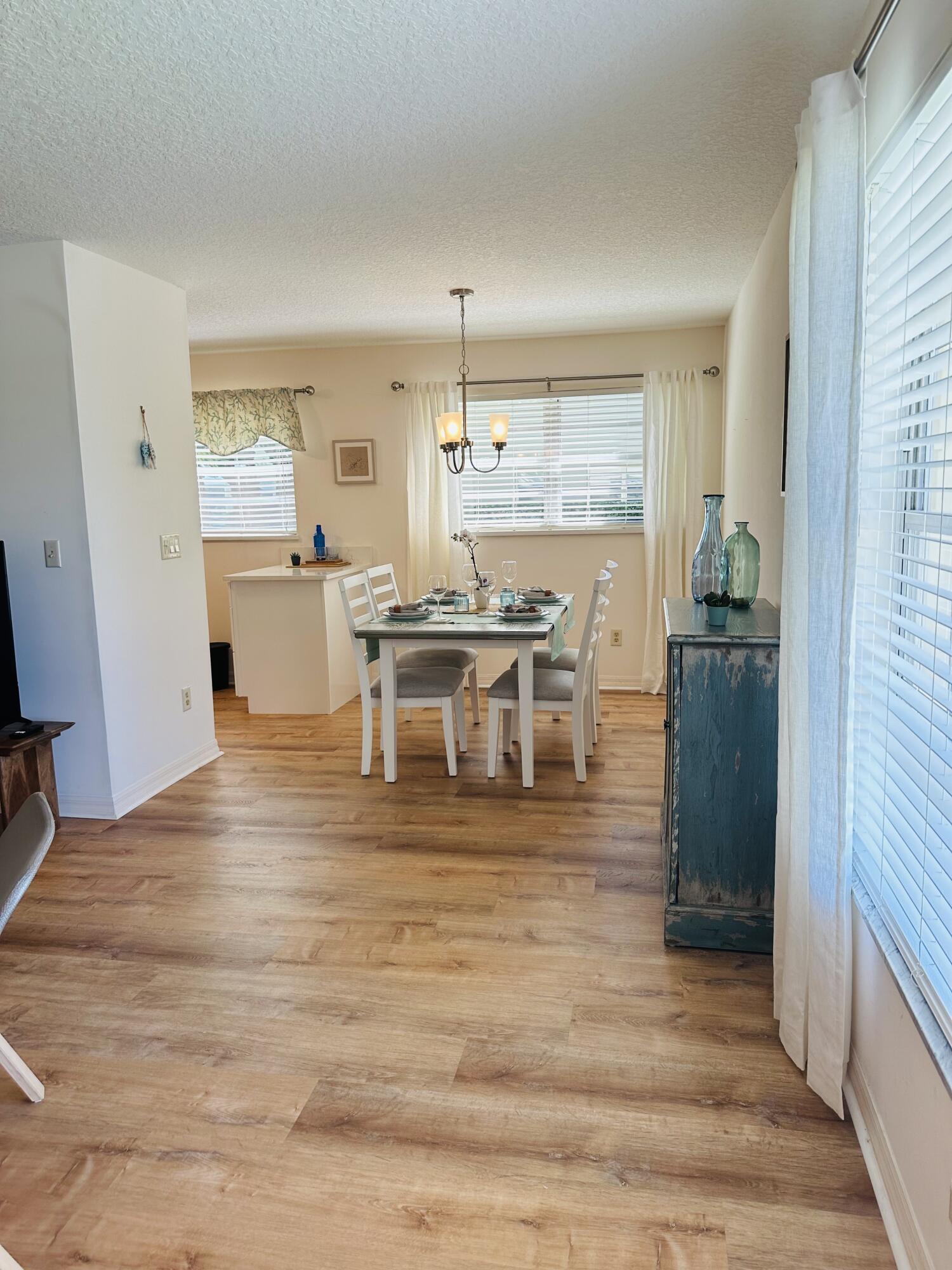 80 Crooked Tree Lane, Unit 106 Vero Beach, FL 32962 - Photo 5 of 47 a view of a kitchen with kitchen island stainless steel appliances wooden floor cabinets and a dining table