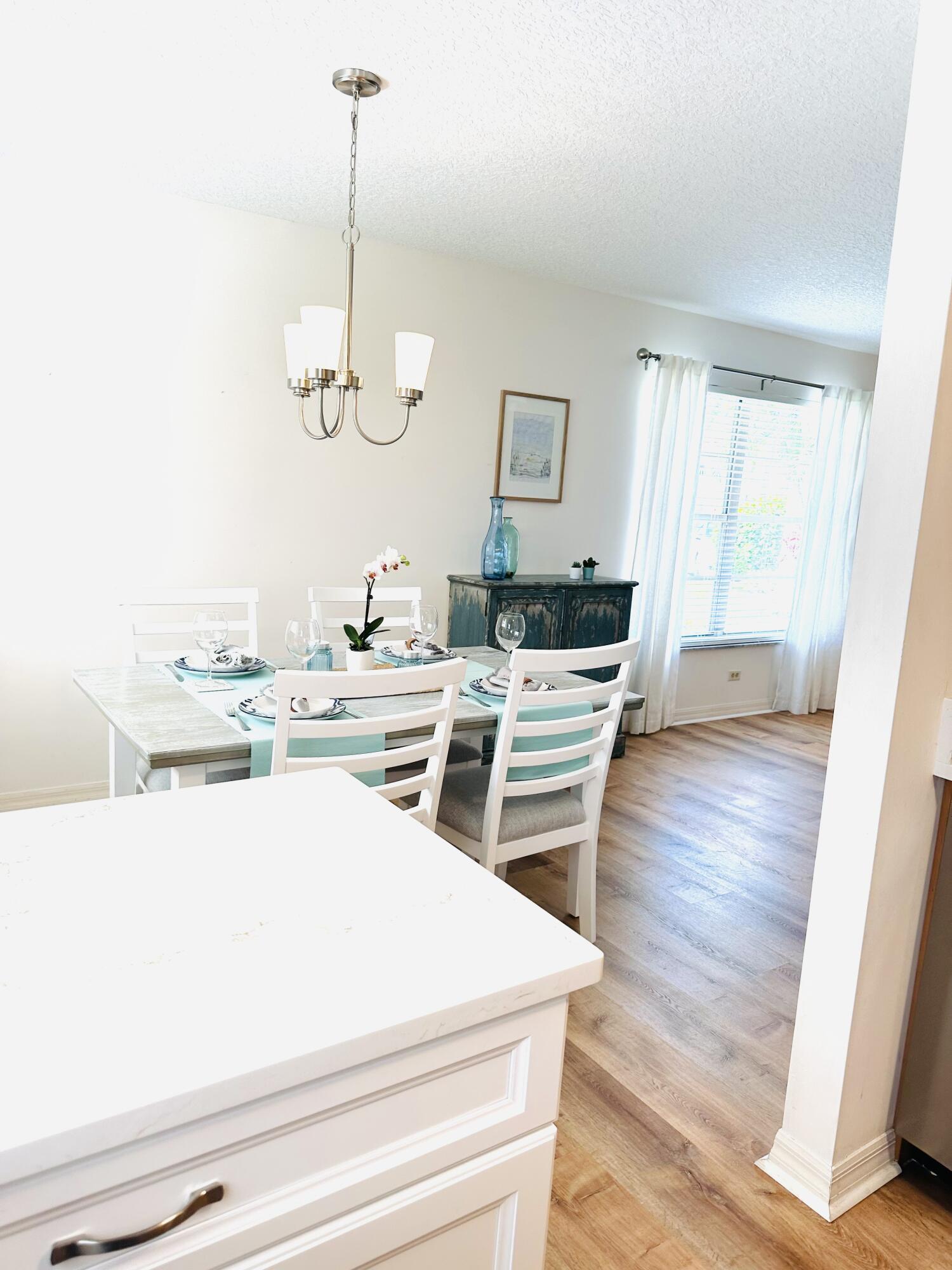80 Crooked Tree Lane, Unit 106 Vero Beach, FL 32962 - Photo 10 of 47 a room with stainless steel appliances kitchen island granite countertop a sink dishwasher and white cabinets with wooden floor