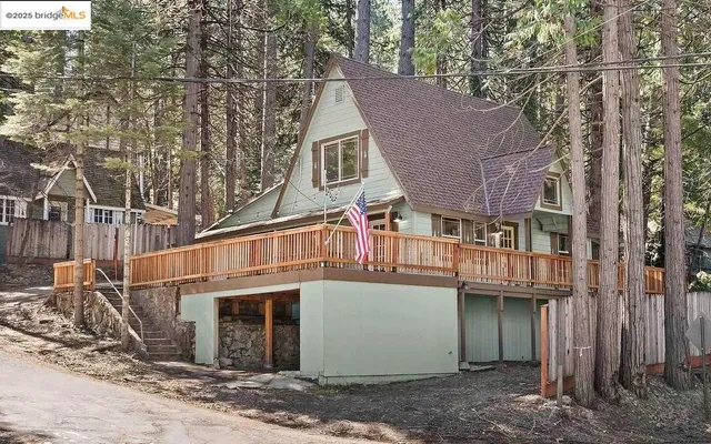 a view of a house with a yard and large tree