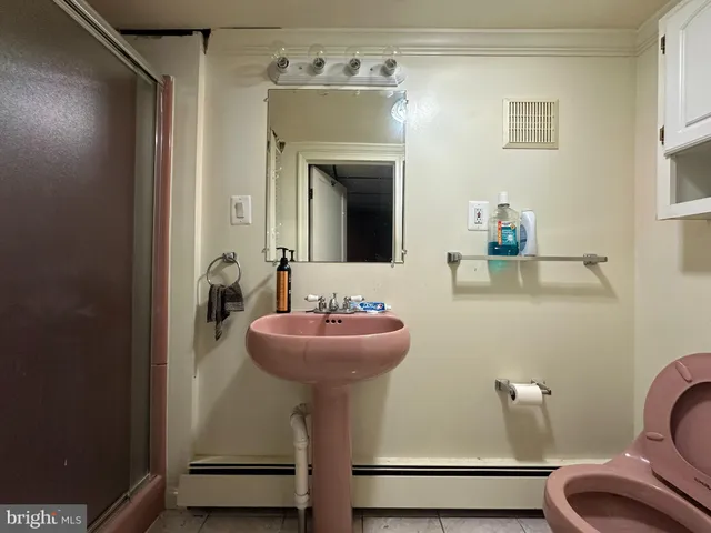 a bathroom with a sink mirror and toilet