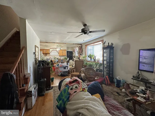 a view of a livingroom with furniture hardwood floor and a ceiling fan