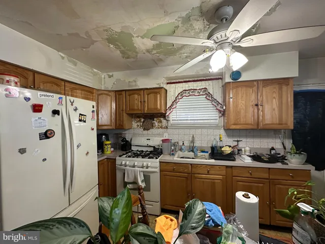 a kitchen with stainless steel appliances granite countertop a refrigerator a sink dishwasher a stove a refrigerator and white cabinets with wooden floor