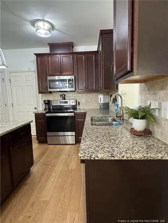 a kitchen with stainless steel appliances granite countertop a sink stove and microwave