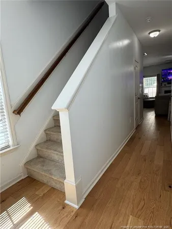 a view of a hallway with wooden floor and stairs