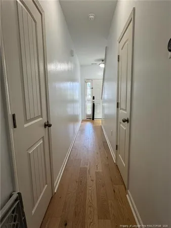 a view of a hallway with wooden floor