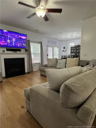 a living room with furniture a flat screen tv and a fireplace