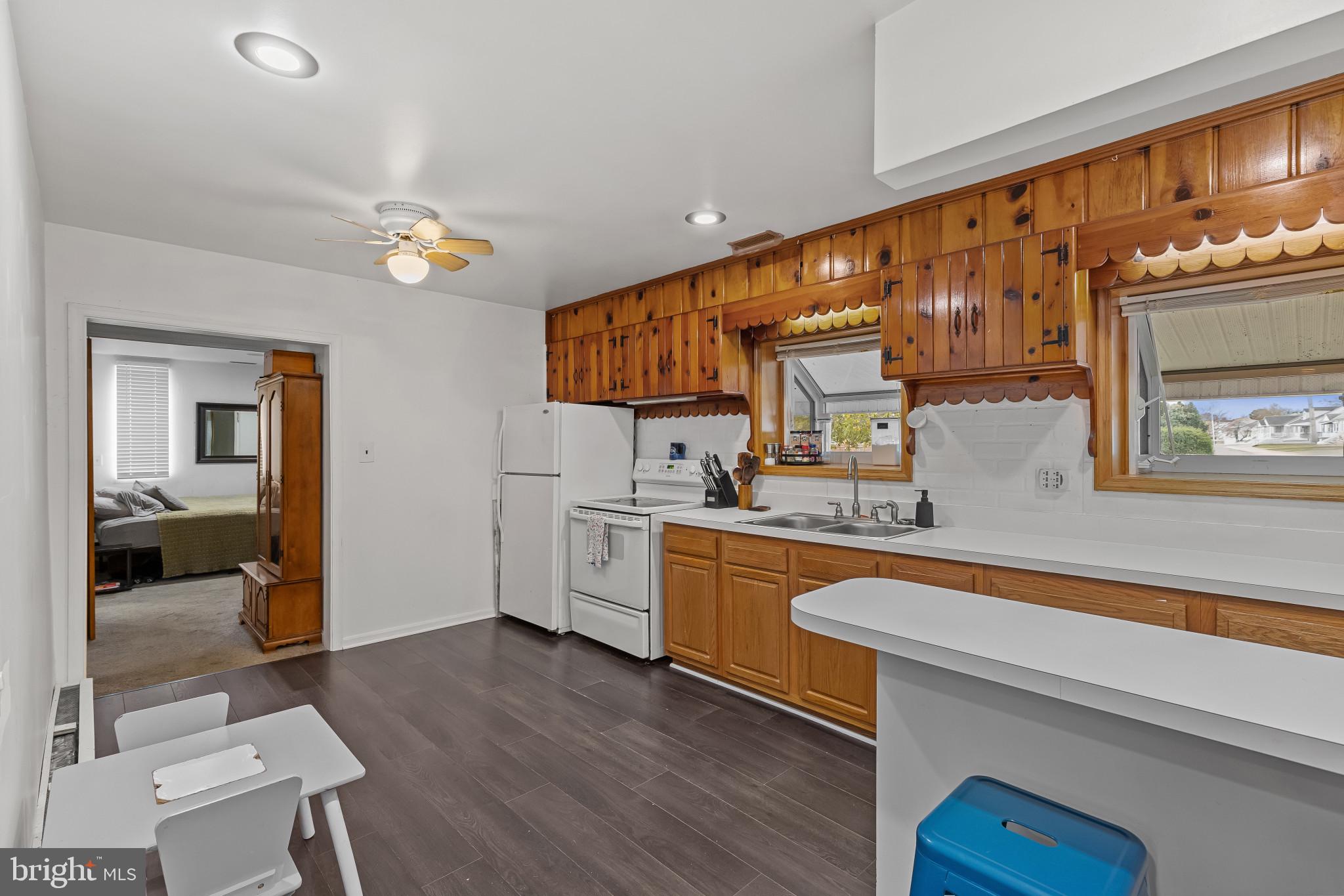 6913 River Drive Road Baltimore, MD 21219 - Photo 11 of 32 a kitchen with stainless steel appliances granite countertop a sink cabinets and wooden floor