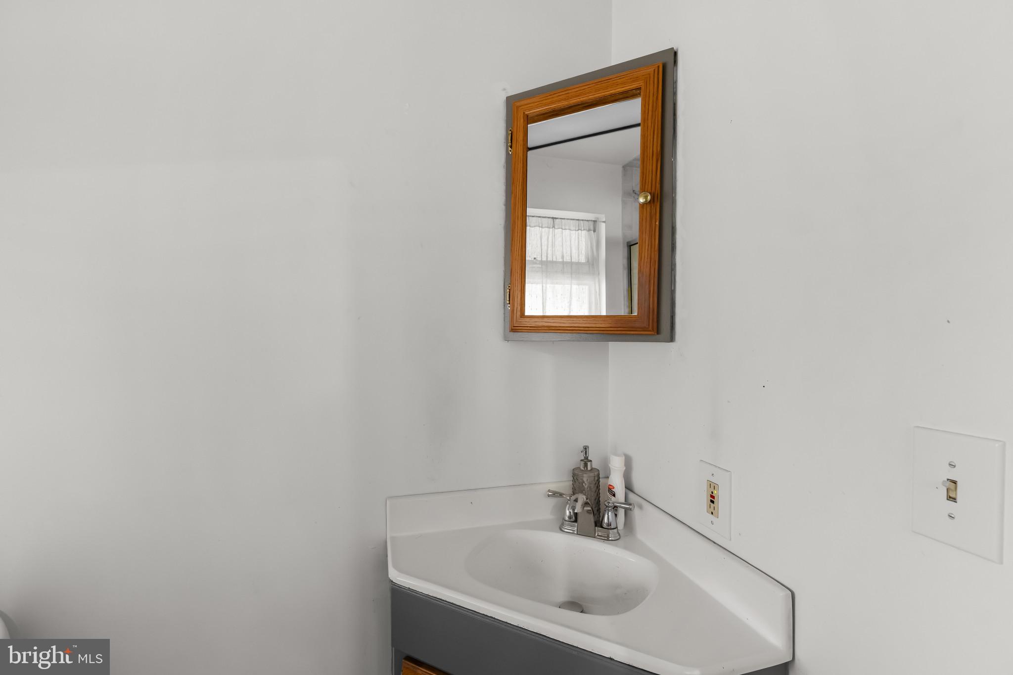 6913 River Drive Road Baltimore, MD 21219 - Photo 24 of 32 a bathroom with a sink and a mirror