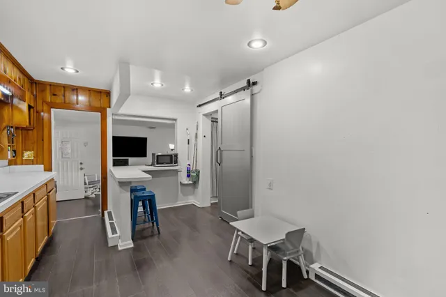 a living room with furniture a flat screen tv and kitchen view