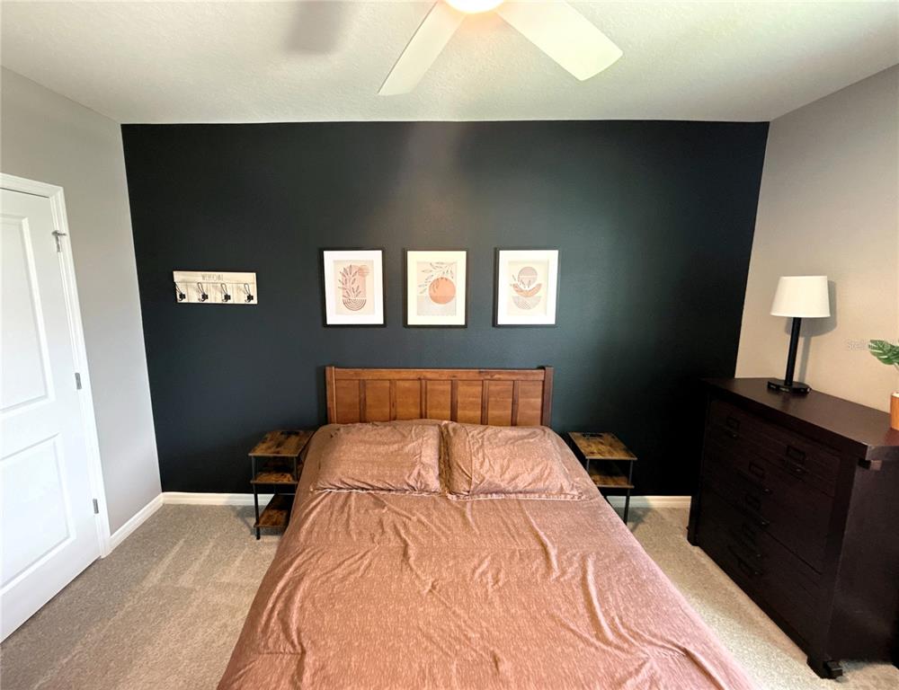 8446 Hardy Bay Loop Wesley Chapel, FL 33545 - Photo 15 of 38 a bedroom with a bed and a lamp on the dresser