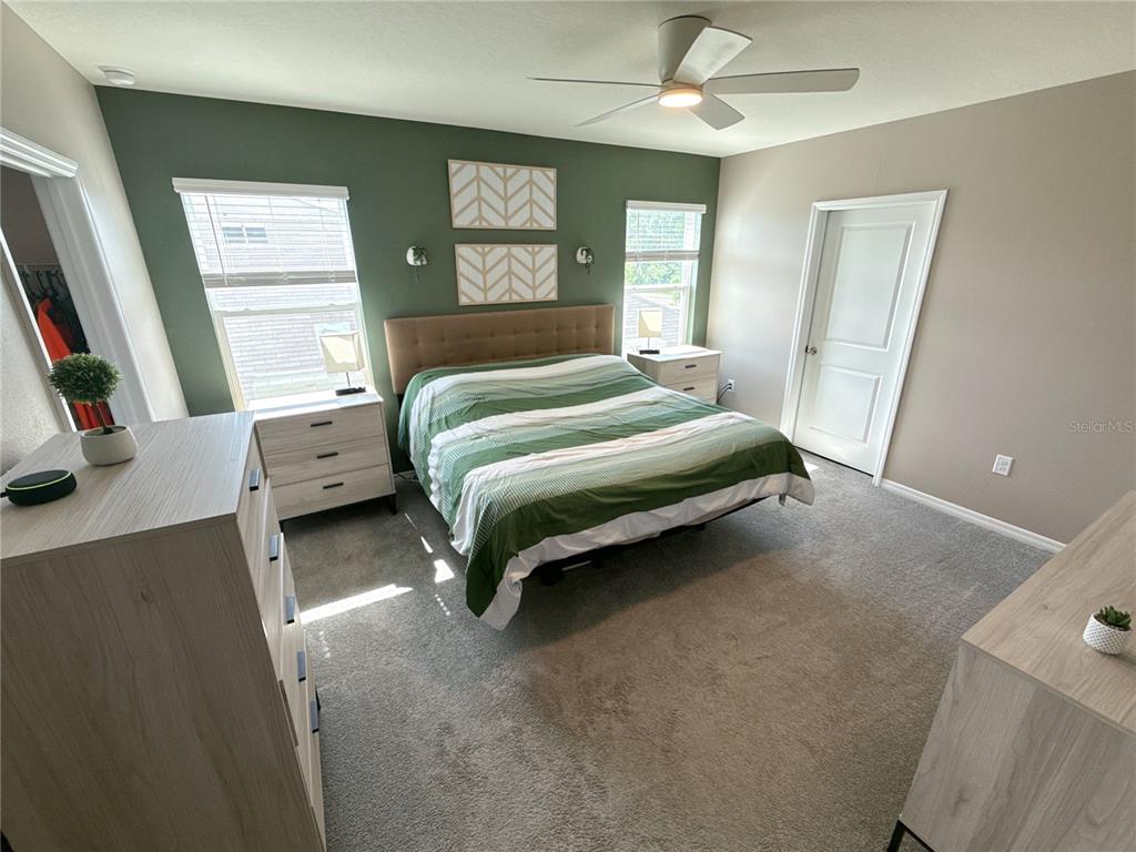 8446 Hardy Bay Loop Wesley Chapel, FL 33545 - Photo 28 of 38 a bedroom with a bed and a flat tv screen on dresser