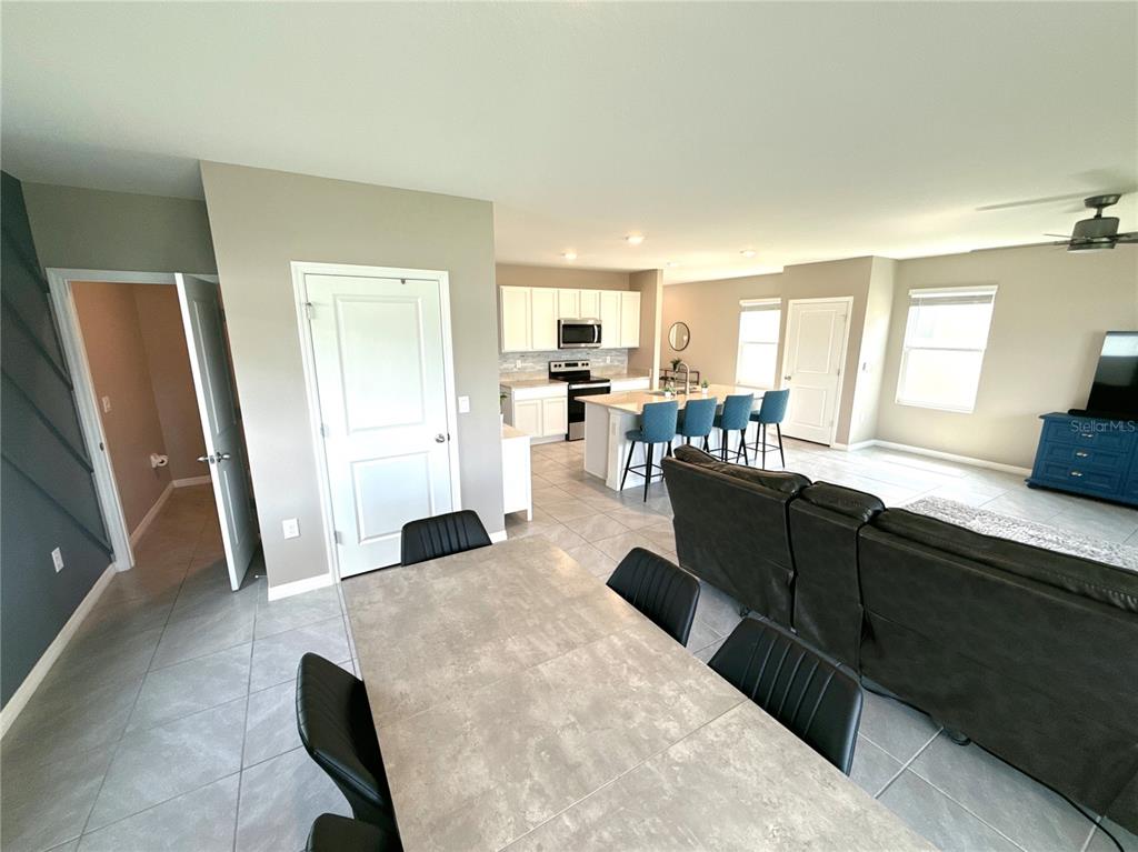 8446 Hardy Bay Loop Wesley Chapel, FL 33545 - Photo 9 of 38 a living room with granite countertop furniture a refrigerator a sink a counter top space and a window