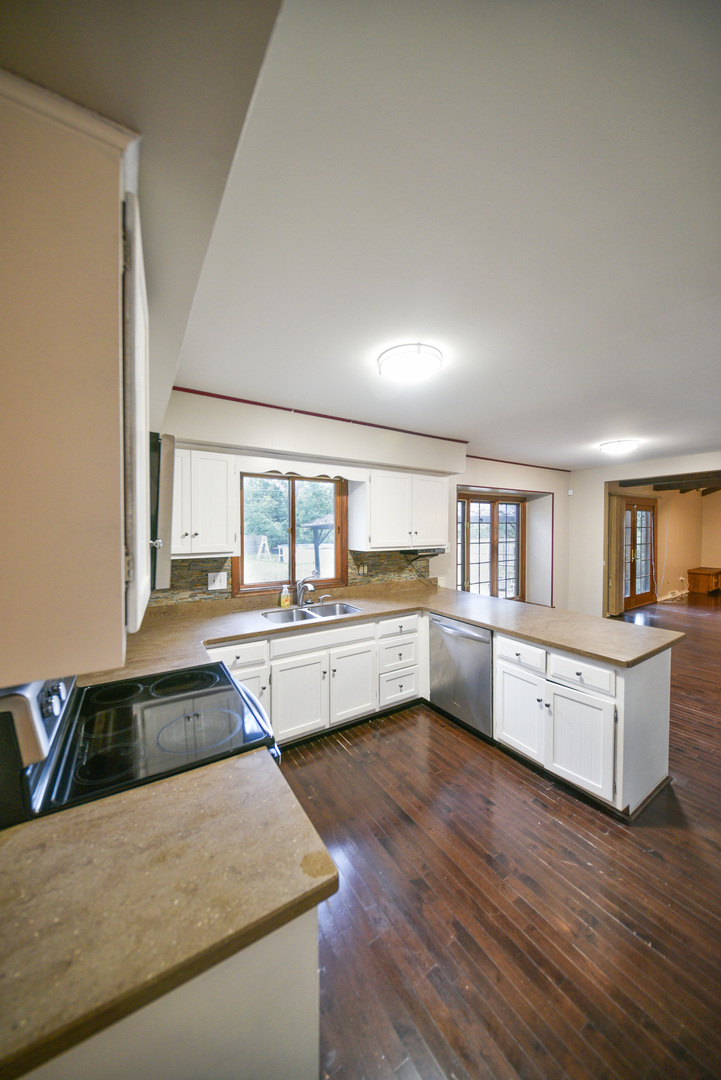 755 Cumnock Road Olympia Fields, IL 60461 - Photo 7 of 34 a kitchen with stainless steel appliances granite countertop a refrigerator a sink dishwasher a stove and white countertops with wooden floor