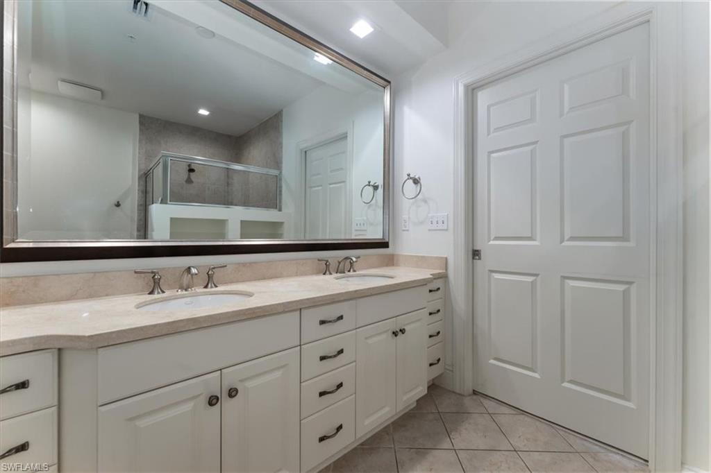 5080 Annunciation Circle, Unit 204 Ave Maria, FL 34142 - Photo 13 of 24 a bathroom with a double vanity sink and mirror
