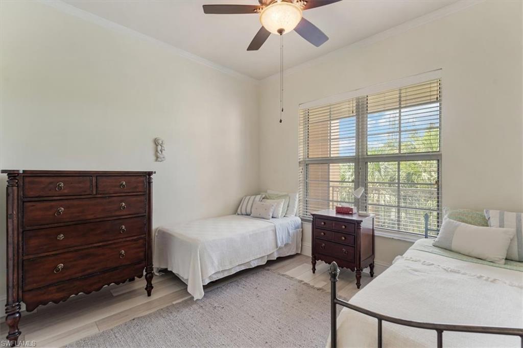 5080 Annunciation Circle, Unit 204 Ave Maria, FL 34142 - Photo 15 of 24 a bedroom with a bed and a chandelier