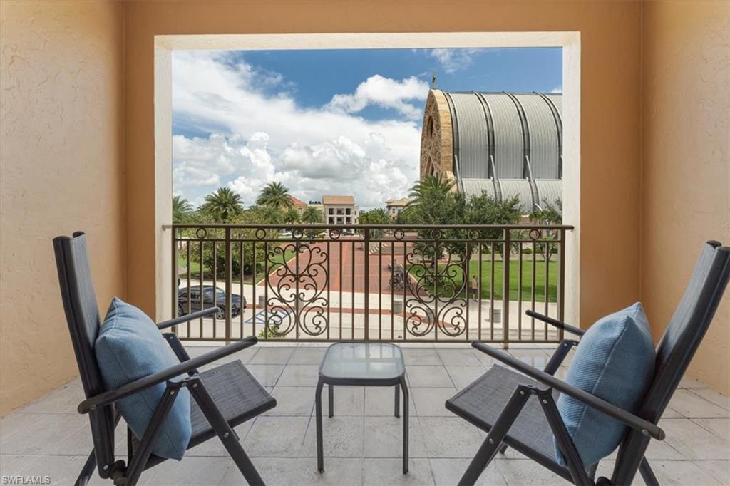 5080 Annunciation Circle, Unit 204 Ave Maria, FL 34142 - Photo 20 of 24 a balcony with table and chairs