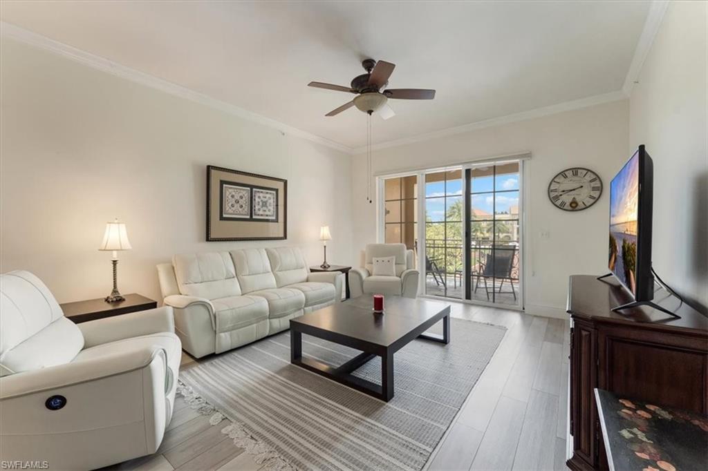 5080 Annunciation Circle, Unit 204 Ave Maria, FL 34142 - Photo 7 of 24 a living room with furniture a flat screen tv and a window