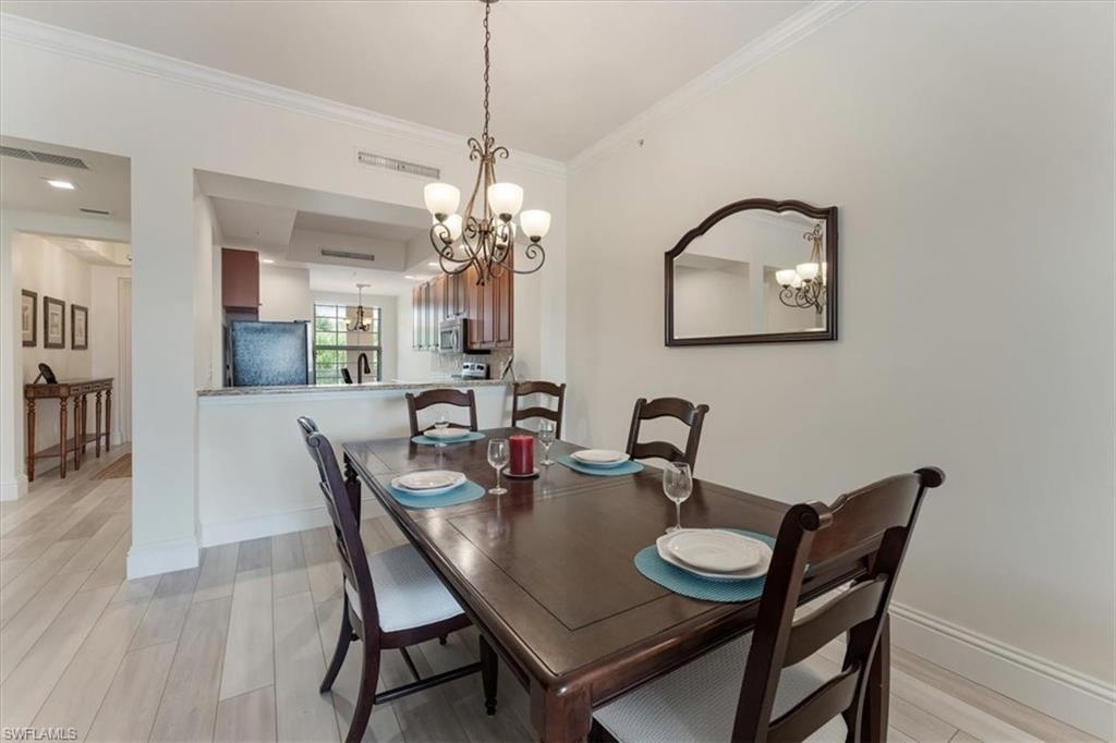 5080 Annunciation Circle, Unit 204 Ave Maria, FL 34142 - Photo 10 of 24 a view of a dining room with furniture and wooden floor