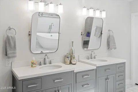 a bathroom with double vanity sinks and a mirror