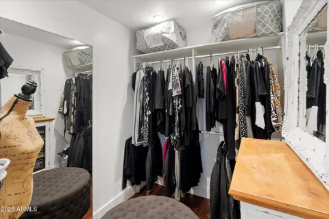 a view of walk in closet with clothes and shoes