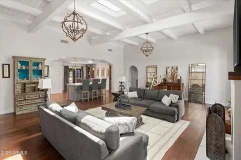 a living room with furniture chandelier and a view of kitchen