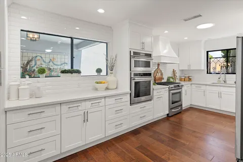 a kitchen with white cabinets and white appliances