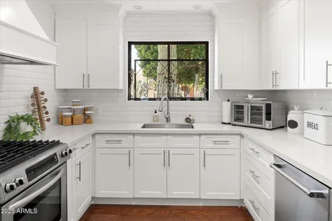 a kitchen with white cabinets and white appliances