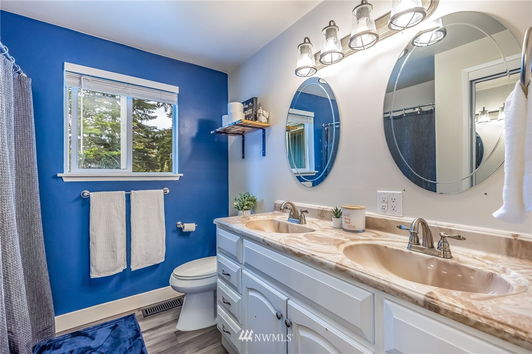 16204 Southeast 132nd Street Renton, WA 98059 - Photo 19 of 38 a bathroom with a granite countertop toilet a sink and a mirror