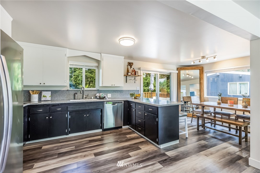 16204 Southeast 132nd Street Renton, WA 98059 - Photo 6 of 38 a large kitchen with kitchen island granite countertop a stove refrigerator and cabinets
