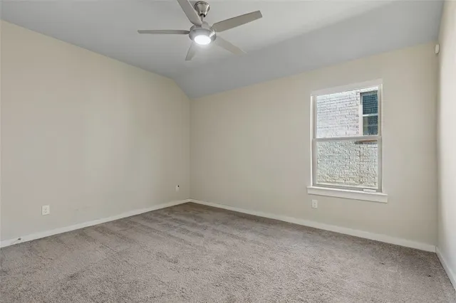an empty room with a window and ceiling fan