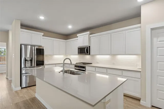 a kitchen with stainless steel appliances granite countertop a refrigerator and a stove top oven