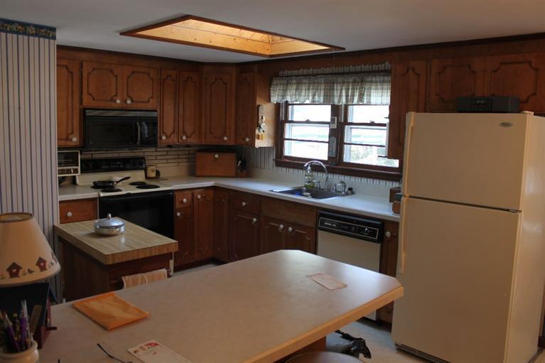 54 Route 149 Marstons Mills, MA 02648 - Photo 5 of 14 a kitchen with a refrigerator a stove a sink dishwasher and wooden cabinets with wooden floor