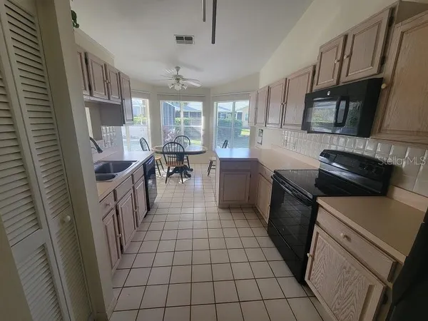 a kitchen with a sink a stove and white cabinets
