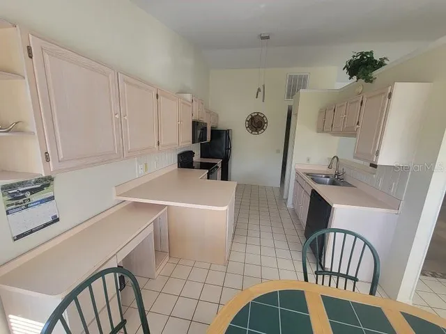 a kitchen with a refrigerator sink and cabinets