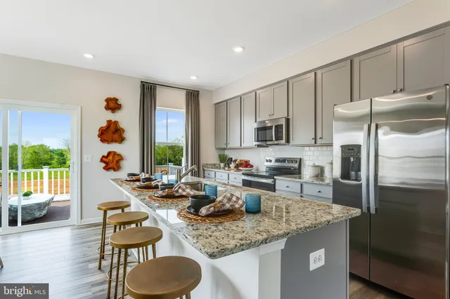 a kitchen with granite countertop sink refrigerator and microwave