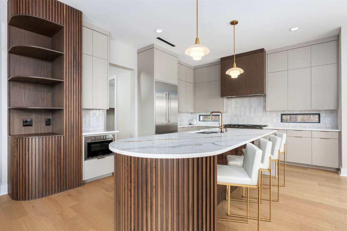 13701 A Montview Drive Austin, TX 78732 - Photo 11 of 40 Oversized island with quartz counter, fluted wood, and 2 dishwashers.
