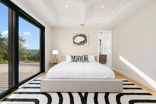 a large white bed in a room next to a window